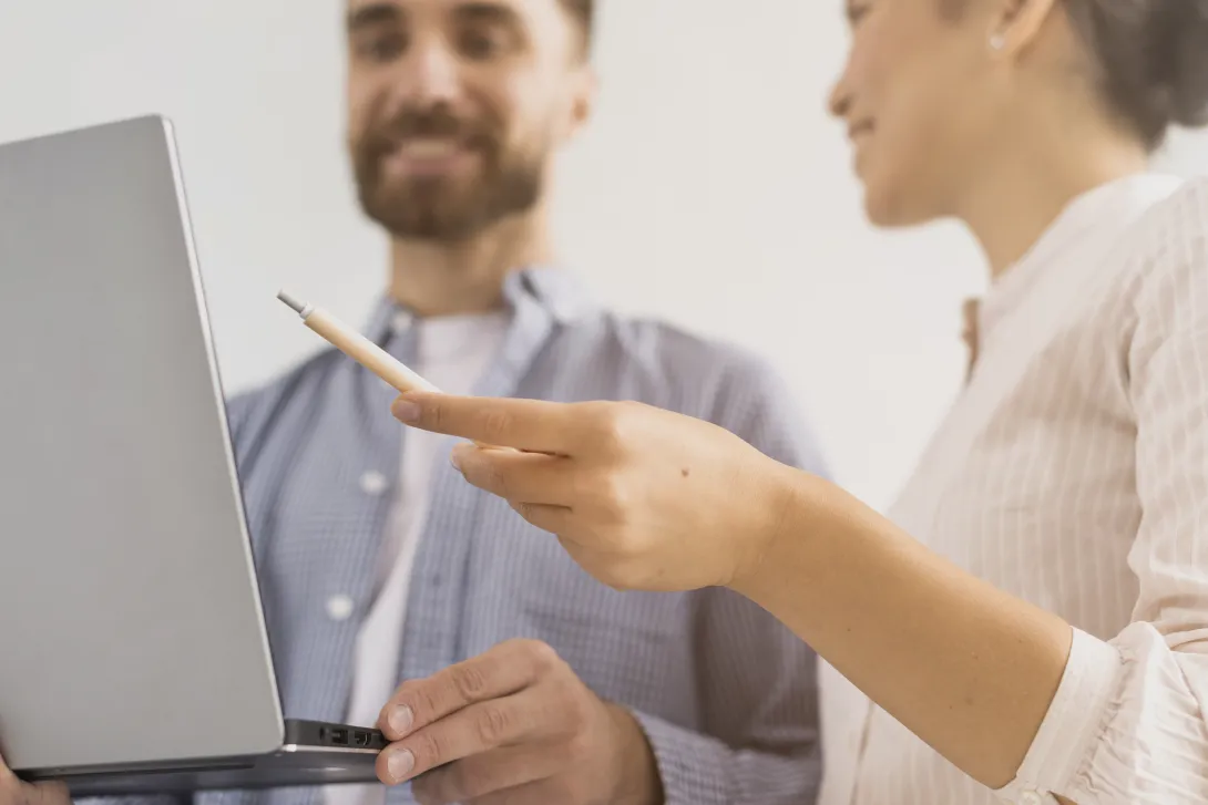 Home i dona davant de l'ordinador compartint informació